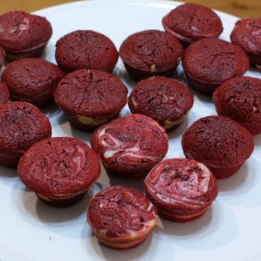 red velvet cheesecake brownie bites on white cake pedestal.