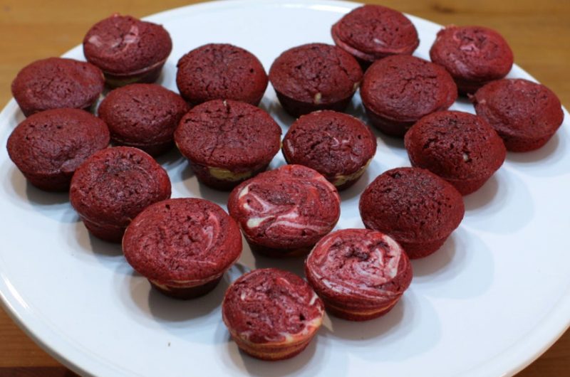 red velvet cheesecake brownie bites on white cake pedestal.