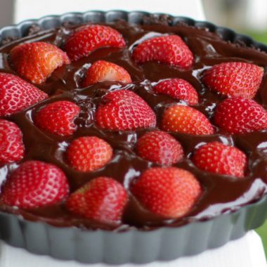 Gluten and dairy free chocolate strawberry tart on a white handrail