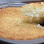 homemade impossible coconut pie in pan on wire rack.