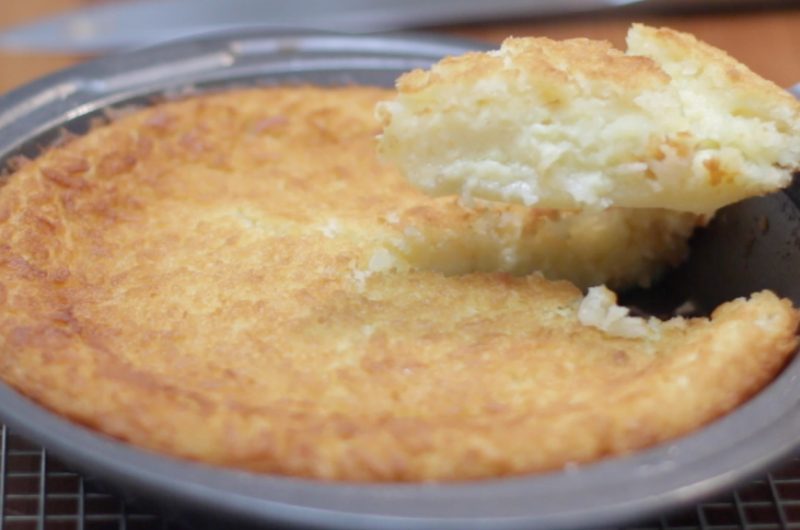 homemade impossible coconut pie in pan on wire rack.