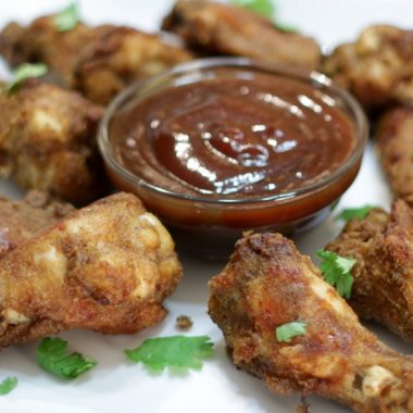 Plate with barbecue sauce and crispy baked oven wings