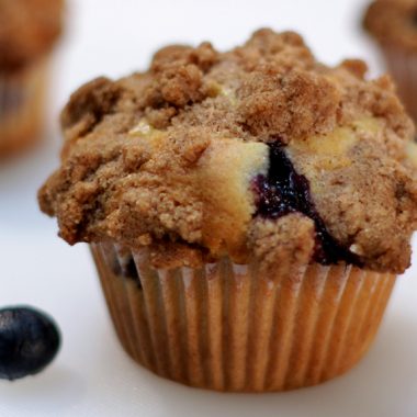 Homemade blueberry muffins on a white cutting board.