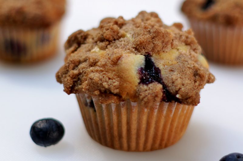 Homemade blueberry muffins on a white cutting board.
