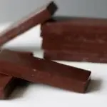 homemade milk chocolate bars stacked on a white plate.