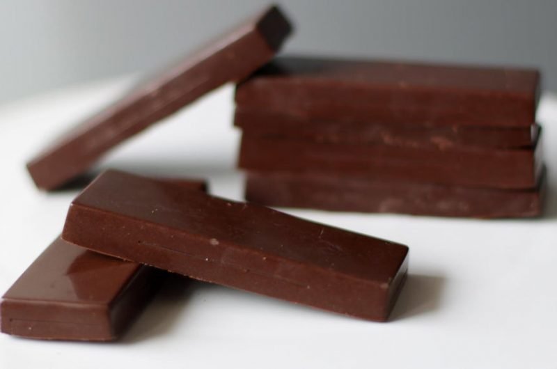 homemade milk chocolate bars stacked on a white plate.