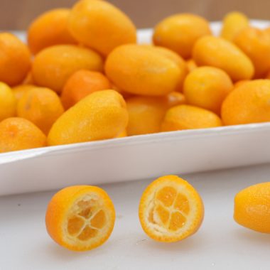 Pile of kumquats in white plate.