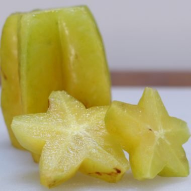 Star fruit on a white cutting board.
