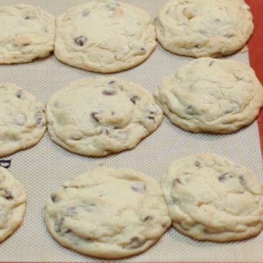 red silicone baking mat with chocolate chip cookies on it