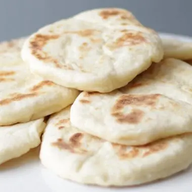 easy flatbread piled up on a white plate