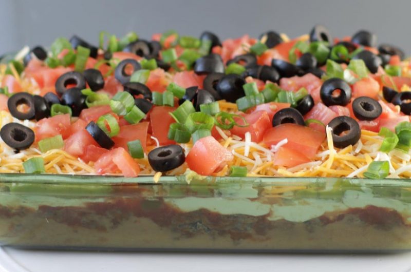 glass dish filled with 7 layer bean dip