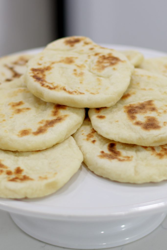 Pile of flatbread on a white plate.
