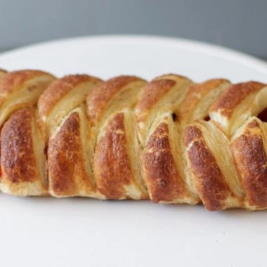 Braided strawberry puff pastry on a white plate