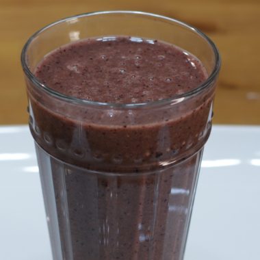 Healthy smoothie in a glass on a white plate.