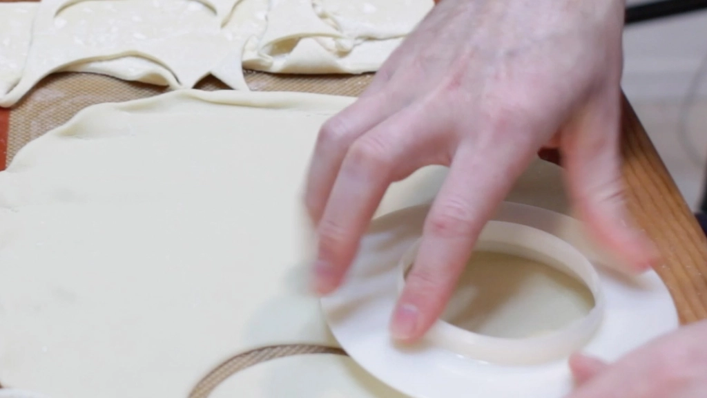Hand cutting round circles out of a pie crust.