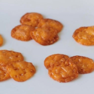 Several homemade cheese crisps on a white plate