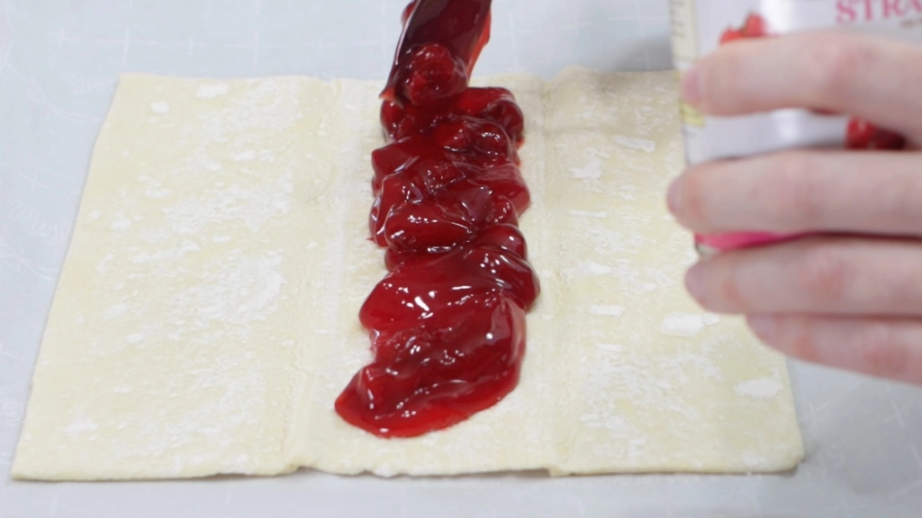 Strawberry pie filling in the middle of the puff pastry sheet.