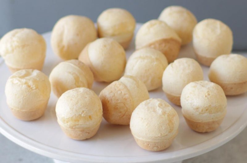 Pile of Brazilian cheese bread on a white plate.