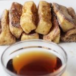Stack of cinnamon french toast sticks on a plate.