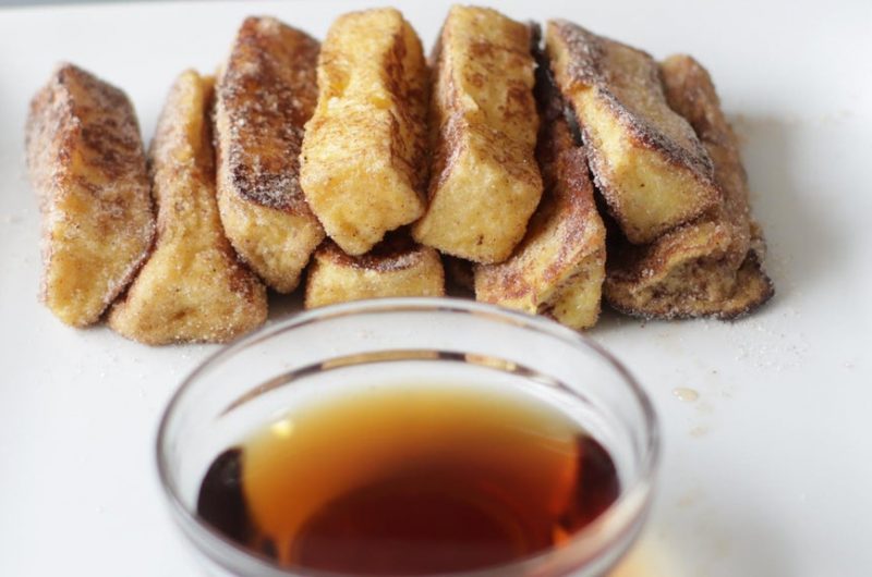 Stack of cinnamon french toast sticks on a plate.