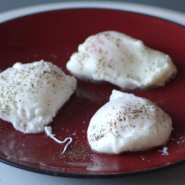 three perfect poached eggs on a red plate