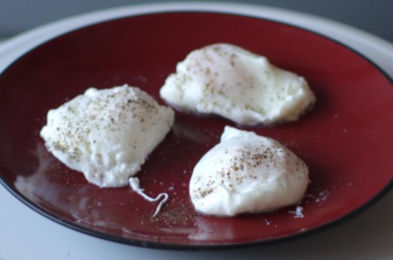 three perfect poached eggs on a red plate