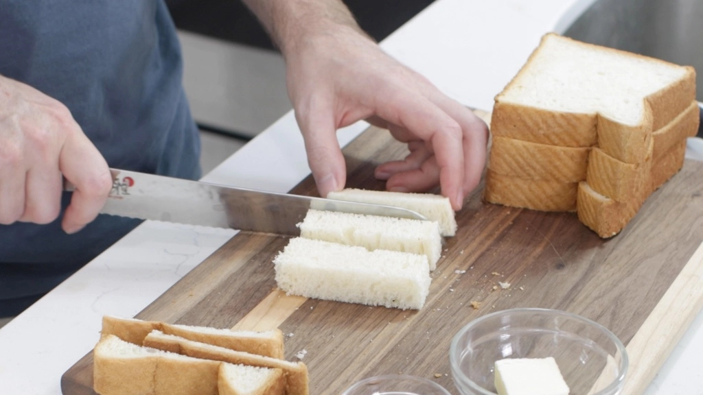 Hand slicing white thick bread.