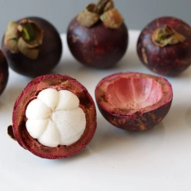 Several mangosteen on a white plate