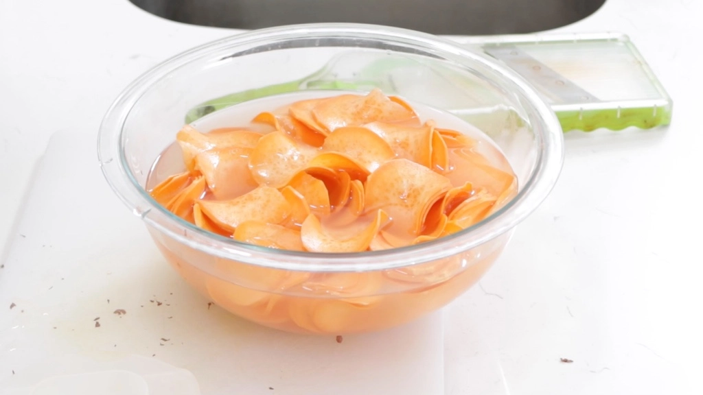 Sweet potato slices in a bowl of water.