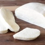 Homemade mozzarella cheese on a wooden cutting board