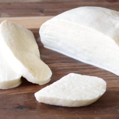 Homemade mozzarella cheese on a wooden cutting board