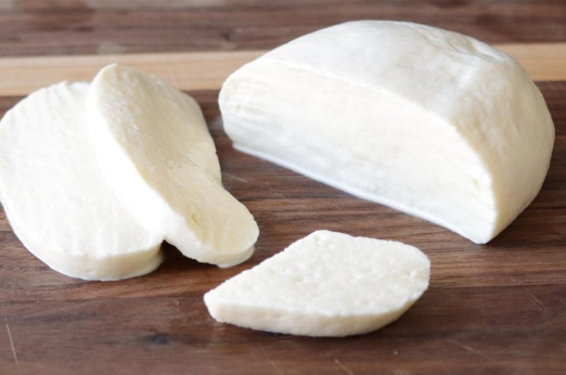 Homemade mozzarella cheese on a wooden cutting board