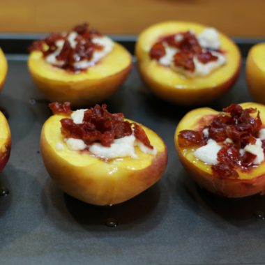 Roasted peaches on a baking pan.