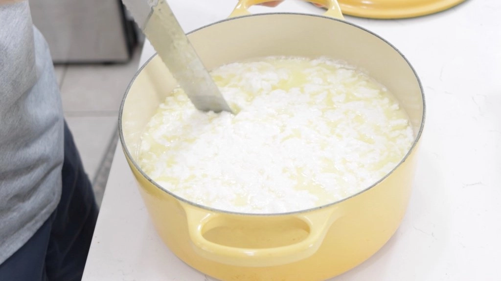 Knife slicing through the mozzarella cheese curd.