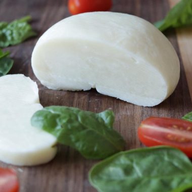 Fresh homemade mozzarella cheese from milk powder on a cutting board.