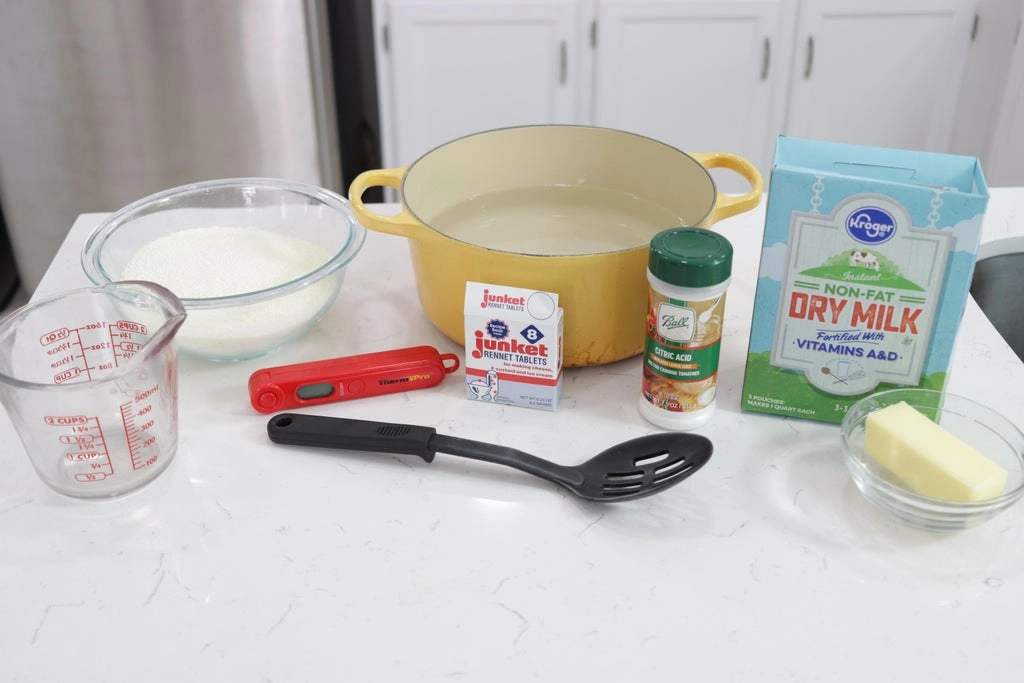 several cheese ingredients on a white countertop.