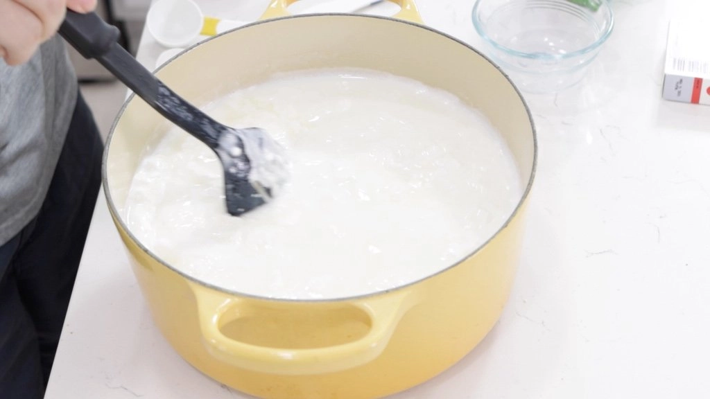 Pot of warm milk and cheese curd