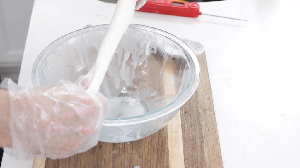 Hand stretching mozzarella cheese.