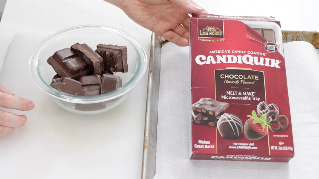 Hand holding a box of CandiQuik melting chocolate.