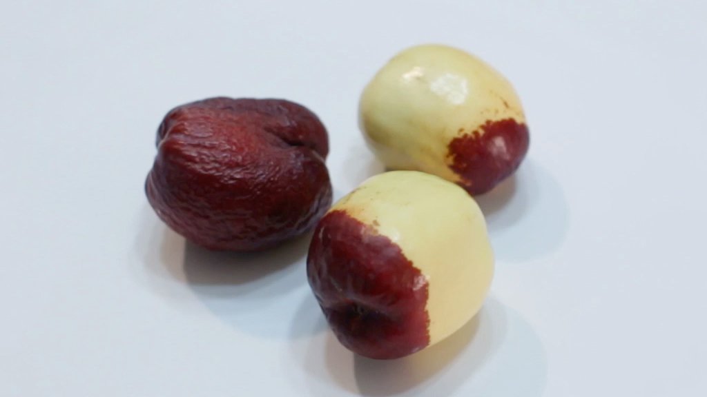 Three Jujube fruit on a white plate