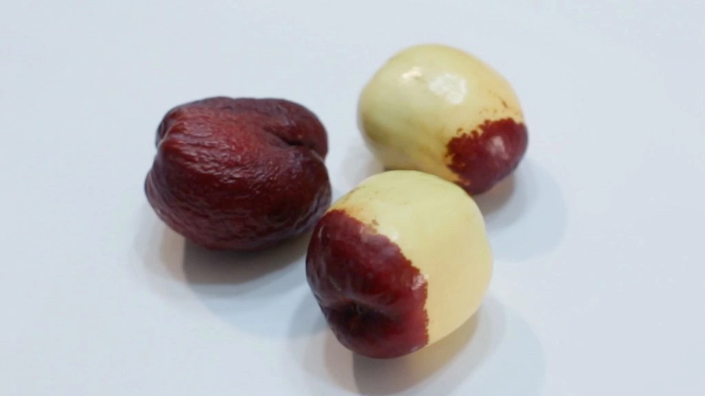 Three Jujube fruit on a white plate