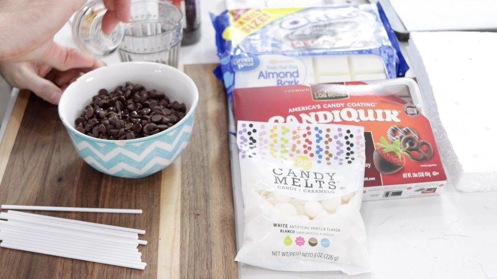 Chocolate chips in a bowl on a wooden cutting board.