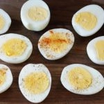 air fryer easy peel hard boiled eggs on a wooden cutting board.