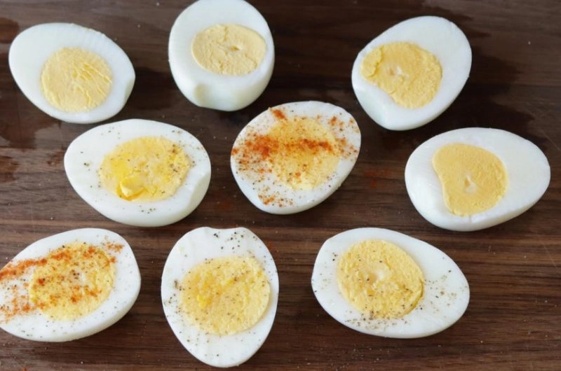 air fryer easy peel hard boiled eggs on a wooden cutting board.