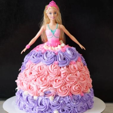 Barbie cake on a white cake pedestal.