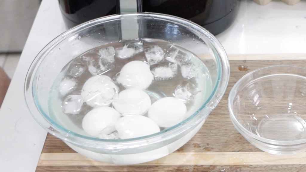 Air fryer hard boiled eggs in bowl of ice water.