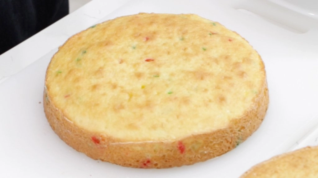 Funfetti cake layer on a white cutting board.