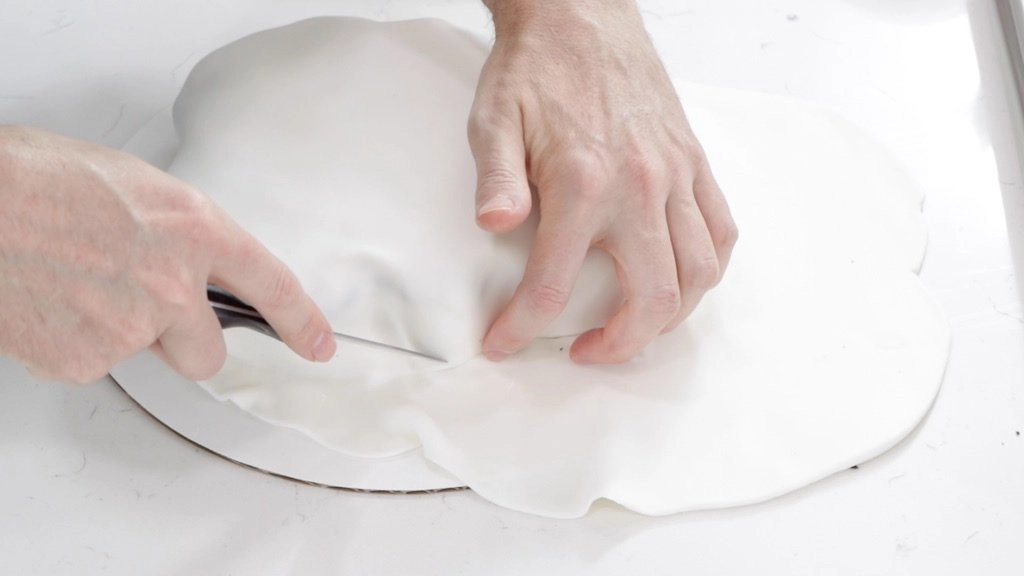 Hand trimming white fondant from the Star Wars Stormtrooper cake