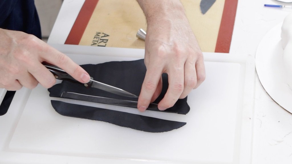 Hand cutting black fondant with a knife