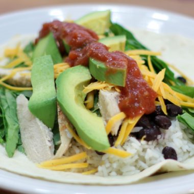Open faced chicken burrito on a white plate